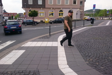 Querungsstelle im Leitsystem am Bahnhof Herborn. Der Bereich um die Bodenindikatoren wurde für die taktile Wahrnehmbarkeit mit glatten Platten belegt.