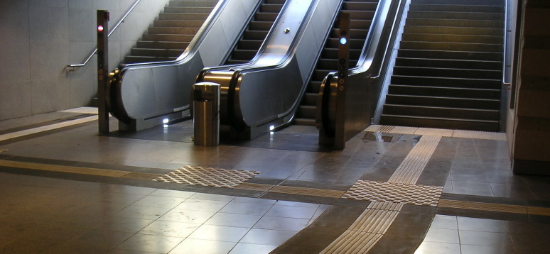 U-Bahn Leipzig: Bodenindikatoren führen zur Treppe, auf die Rolltreppe weist ein Abzweigefeld hin.